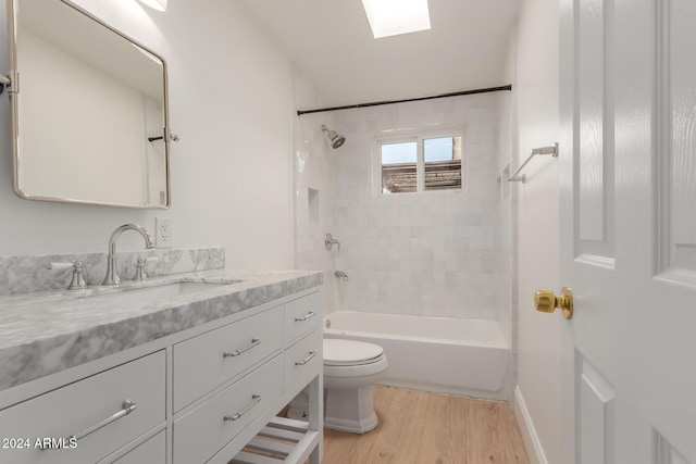 full bathroom with hardwood / wood-style floors, vanity, toilet, and tiled shower / bath