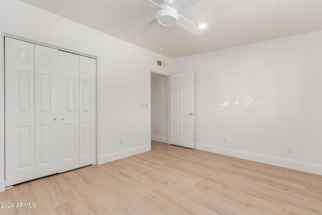 unfurnished bedroom with ceiling fan, light wood-type flooring, and a closet