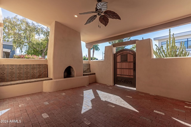 view of patio featuring a large fireplace and ceiling fan