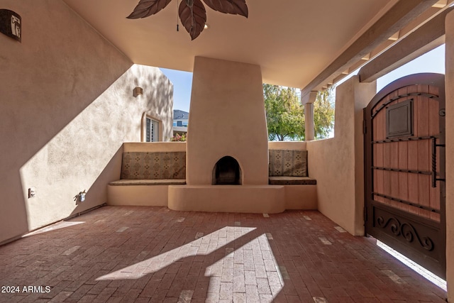 view of patio / terrace featuring ceiling fan and a large fireplace