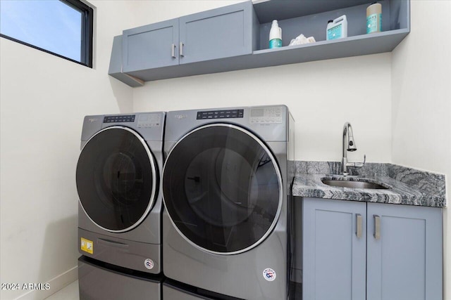 laundry area with washer and dryer, sink, and cabinets