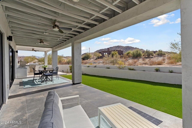 view of patio featuring ceiling fan and a mountain view