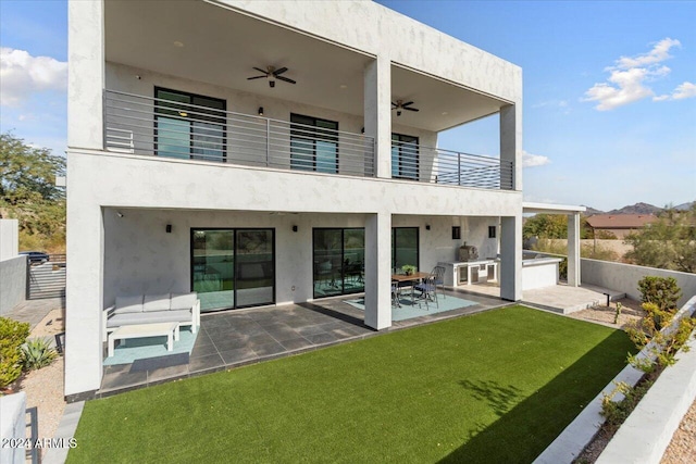 rear view of house featuring a lawn, ceiling fan, a patio area, a balcony, and area for grilling