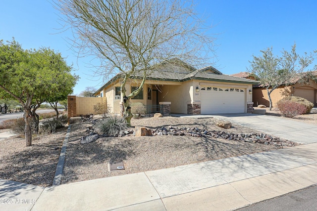 view of front of home featuring fence, stucco siding, concrete driveway, a garage, and stone siding