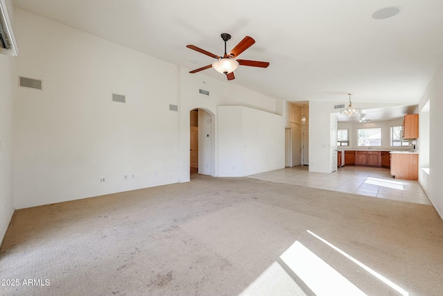 28604 N 21st Ln, Phoenix, AZ 85085 - unfurnished living room featuring arched walkways, visible vents, ceiling fan with notable chandelier, and light colored carpet