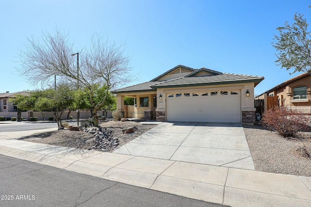 view of front facade with fence, a tiled roof, a garage, stone siding, and driveway