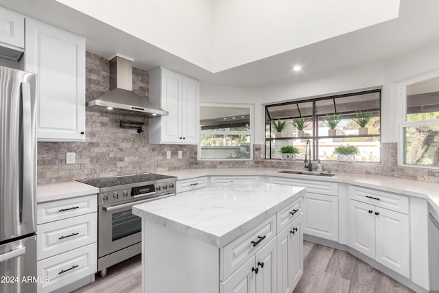 10338 E San Salvador Dr, Scottsdale, AZ 85258 - kitchen featuring wall chimney range hood, stainless steel appliances, a sink, backsplash, and white cabinetry