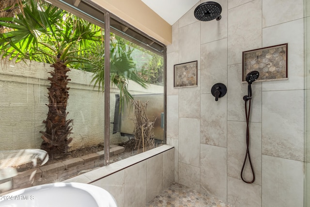 bathroom featuring a tile shower and lofted ceiling