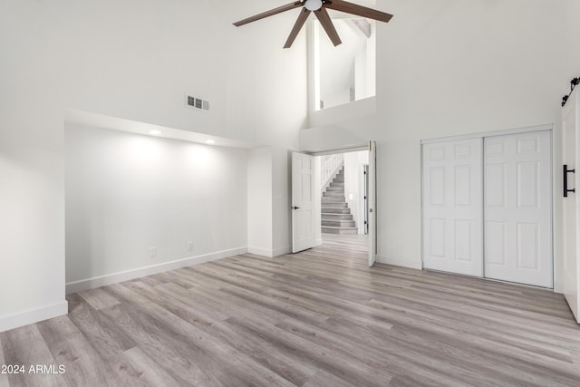 10338 E San Salvador Dr, Scottsdale, AZ 85258 - unfurnished bedroom featuring baseboards, wood finished floors, a high ceiling, a closet, and ceiling fan
