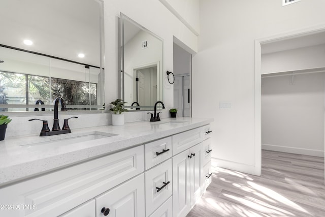 10338 E San Salvador Dr, Scottsdale, AZ 85258 - bathroom featuring wood finished floors, double vanity, and recessed lighting
