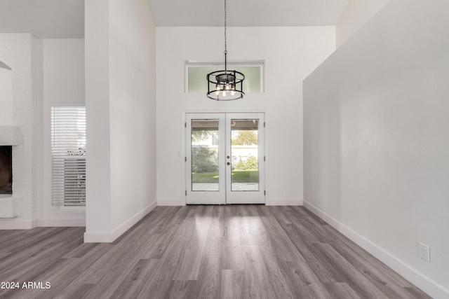 10338 E San Salvador Dr, Scottsdale, AZ 85258 - foyer featuring french doors, a chandelier, wood finished floors, baseboards, and a brick fireplace