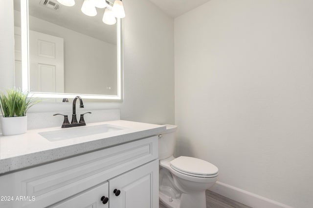 10338 E San Salvador Dr, Scottsdale, AZ 85258 - half bathroom featuring vanity, toilet, baseboards, and wood finished floors