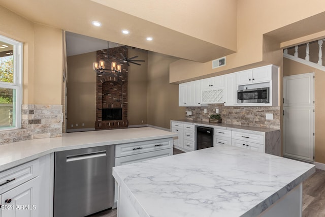 kitchen with appliances with stainless steel finishes, tasteful backsplash, ceiling fan, wood-type flooring, and white cabinetry