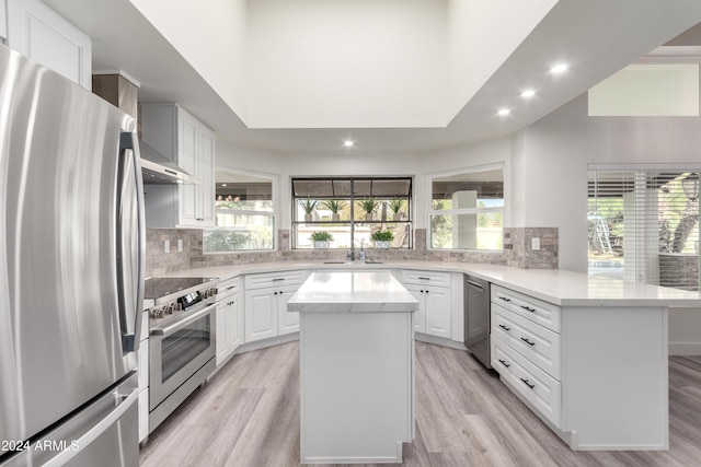 10338 E San Salvador Dr, Scottsdale, AZ 85258 - kitchen with appliances with stainless steel finishes, recessed lighting, a peninsula, light wood-style flooring, and backsplash