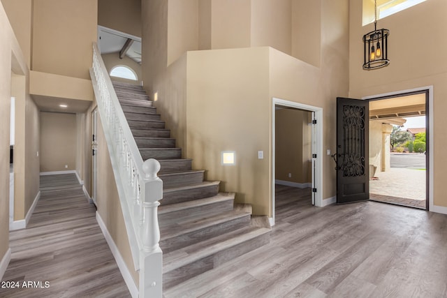 foyer with beam ceiling, light hardwood / wood-style floors, and high vaulted ceiling