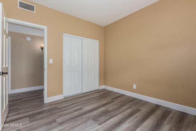 unfurnished bedroom with wood-type flooring and a closet