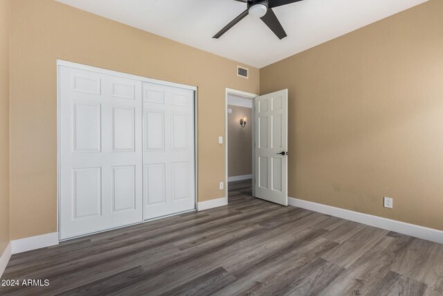 unfurnished bedroom featuring a closet, dark hardwood / wood-style floors, and ceiling fan