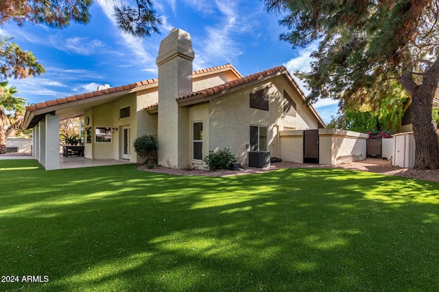 10338 E San Salvador Dr, Scottsdale, AZ 85258 - rear view of property with a chimney, stucco siding, cooling unit, a tile roof, and a yard