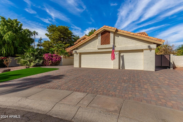 10338 E San Salvador Dr, Scottsdale, AZ 85258 - view of front of home featuring a garage, decorative driveway, stucco siding, fence, and a tile roof