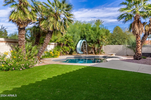 view of pool with a yard, a diving board, a patio area, and a water slide