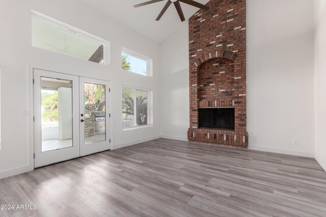 10338 E San Salvador Dr, Scottsdale, AZ 85258 - unfurnished living room with high vaulted ceiling, a ceiling fan, wood finished floors, a fireplace, and baseboards