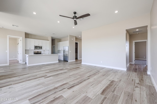 unfurnished living room featuring light hardwood / wood-style floors and ceiling fan