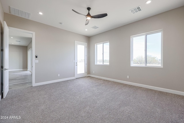 spare room featuring light carpet and ceiling fan