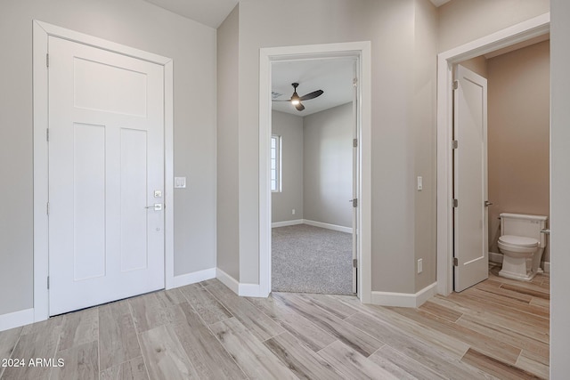 foyer entrance with ceiling fan and light wood-type flooring