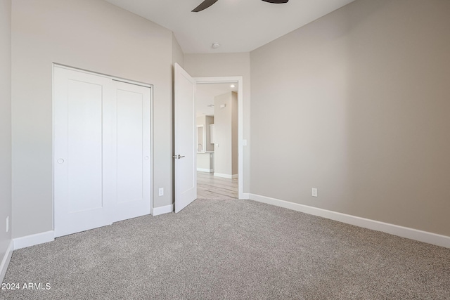 unfurnished bedroom featuring carpet, ceiling fan, and a closet