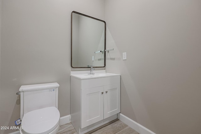 bathroom featuring vanity, hardwood / wood-style flooring, and toilet