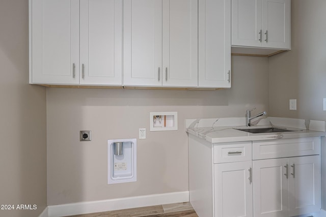 laundry area featuring cabinets, hookup for a washing machine, light wood-type flooring, electric dryer hookup, and sink