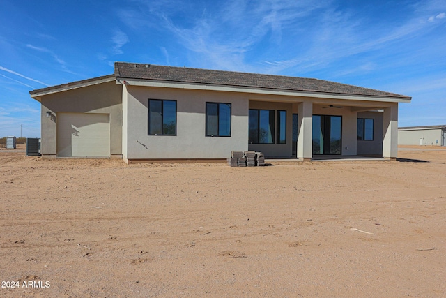 back of house with central AC, ceiling fan, and a garage