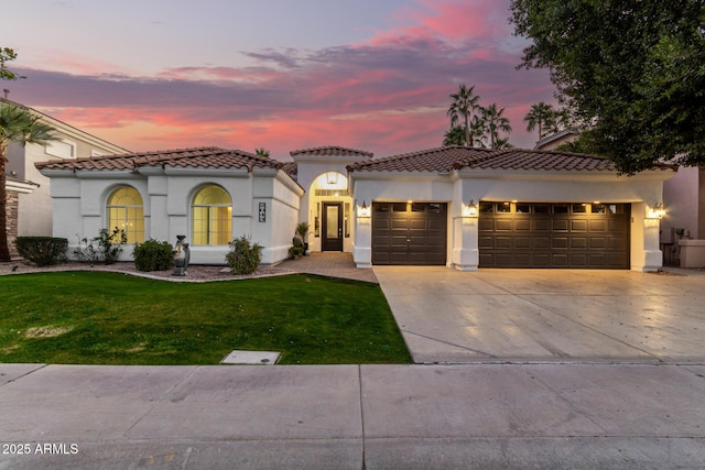 mediterranean / spanish house with a garage and a yard