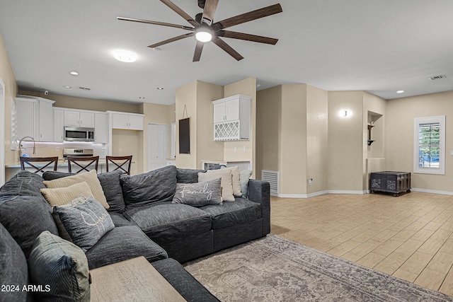 living room with ceiling fan and light hardwood / wood-style flooring