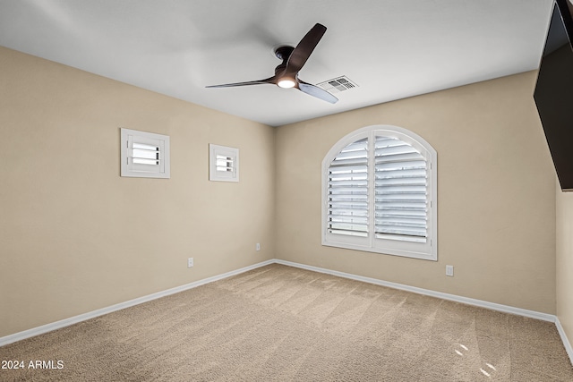 carpeted spare room featuring ceiling fan