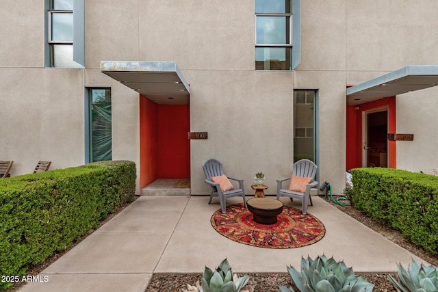 entrance to property with a patio and stucco siding