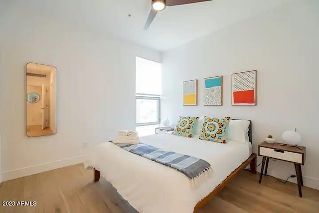 bedroom with ceiling fan, baseboards, and wood finished floors