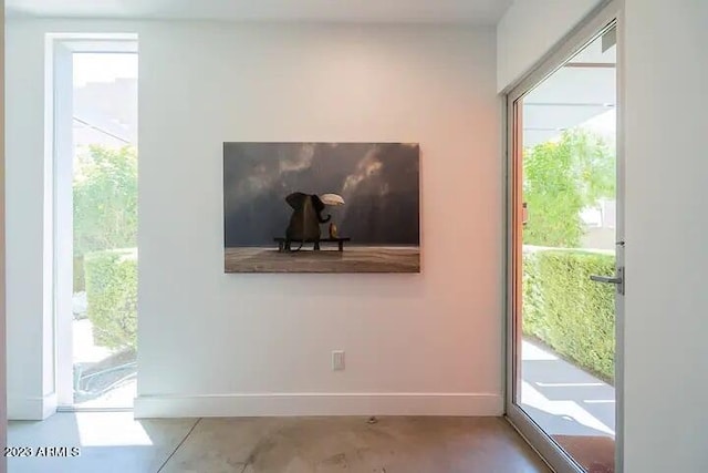 doorway with concrete floors and baseboards