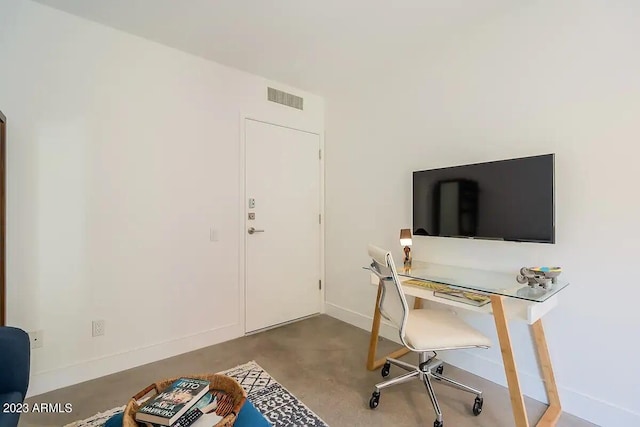 office with finished concrete floors, visible vents, and baseboards