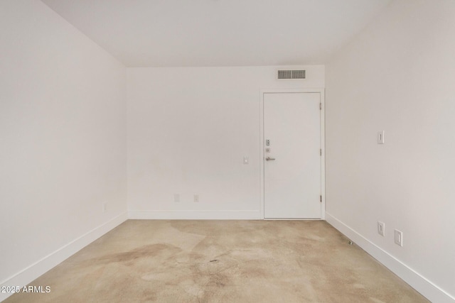 spare room featuring light carpet, baseboards, and visible vents