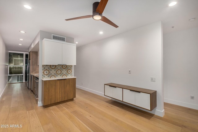 kitchen featuring visible vents, white cabinets, decorative backsplash, light wood-style flooring, and light countertops