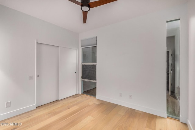 unfurnished bedroom with light wood finished floors, a closet, ensuite bathroom, a ceiling fan, and baseboards