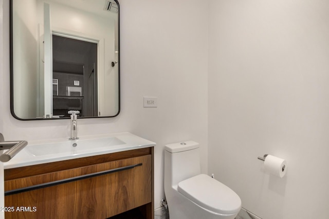 half bath with toilet, visible vents, and vanity