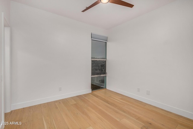 empty room with ceiling fan, wood finished floors, and baseboards