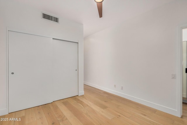 unfurnished bedroom with light wood finished floors, a closet, visible vents, and baseboards