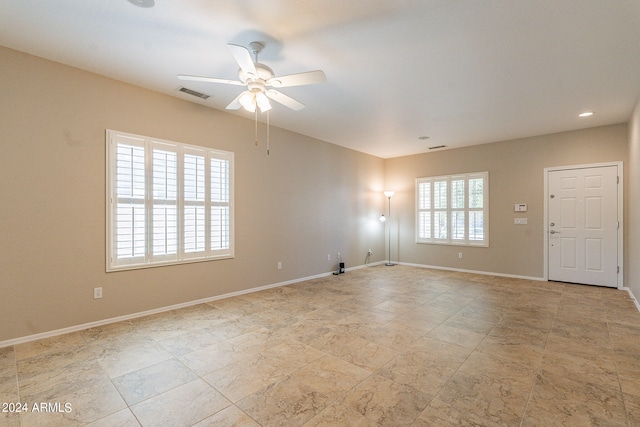 tiled empty room featuring ceiling fan