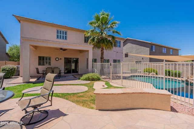 rear view of property with central AC, ceiling fan, a fenced in pool, and a patio