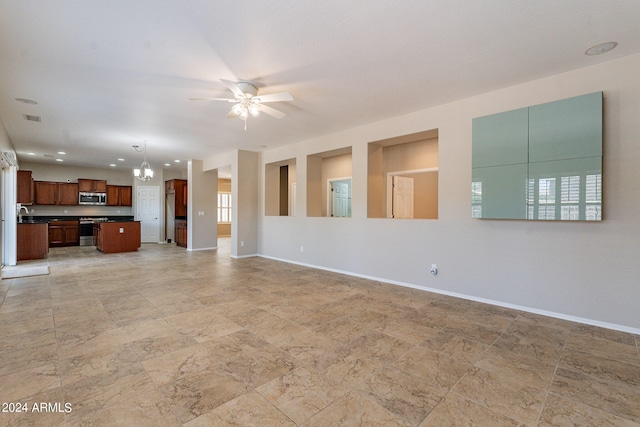 unfurnished living room with ceiling fan with notable chandelier and light tile floors