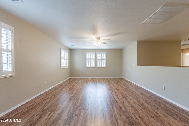 unfurnished room with wood-type flooring, plenty of natural light, and ceiling fan