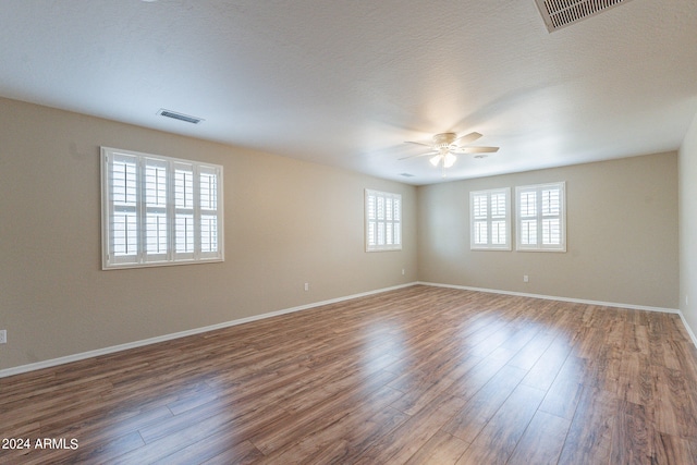 unfurnished room with plenty of natural light, ceiling fan, and hardwood / wood-style flooring